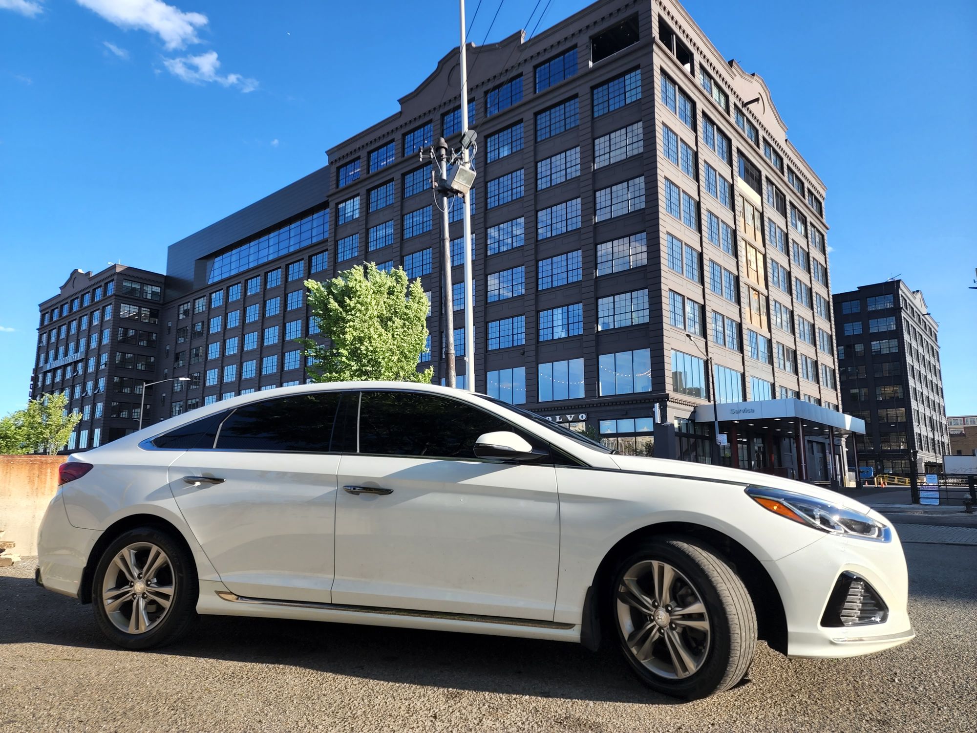 Adolfo's 2019 white Hyundai Sonata parked outdoors on a sunny day with clear skies.