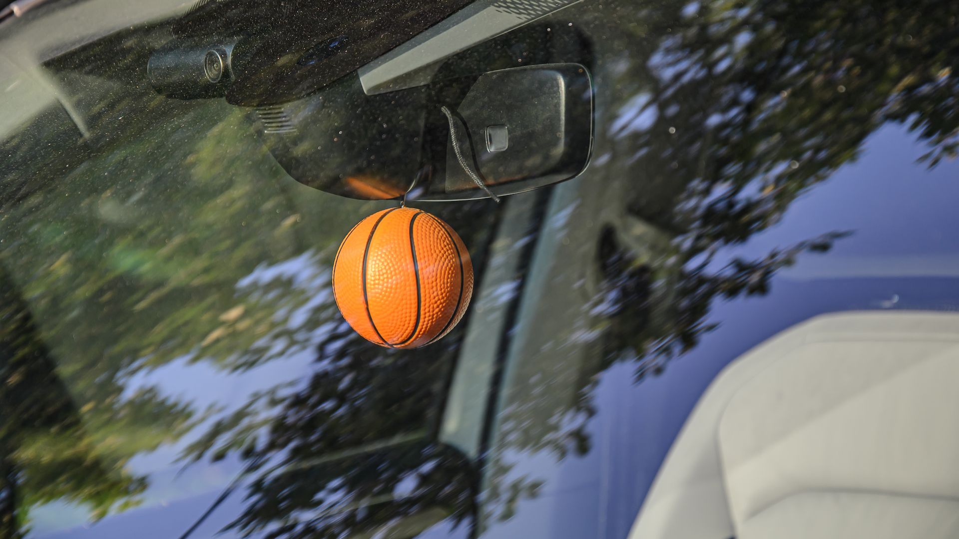 A basketball hanging from a rear-view mirror